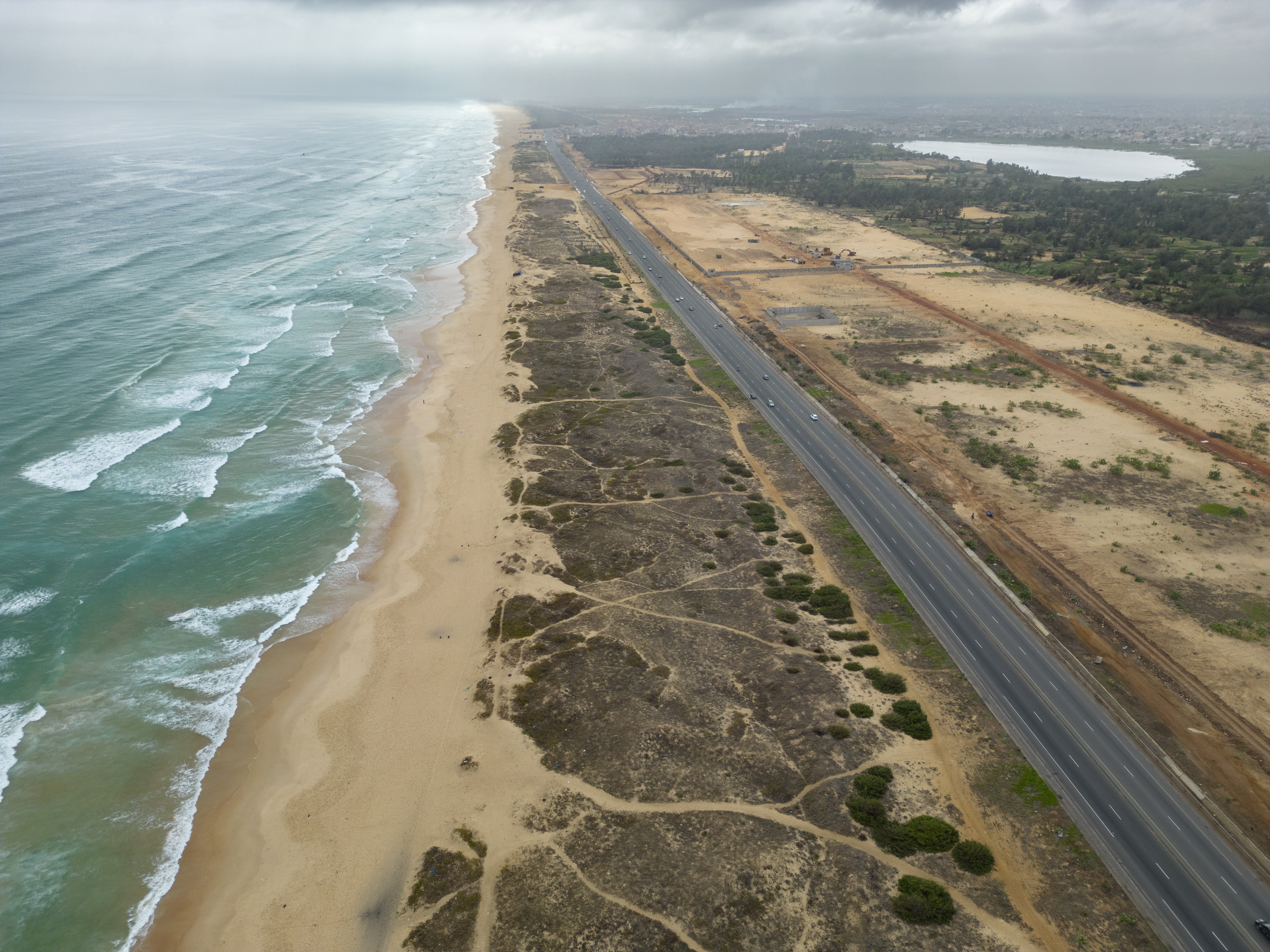 Sólo 200 metros separan el mar de la carretera y las casas. Las dunas de arena actúan como barreras naturales contra el avance de las aguas. Ante la erosión costera y las inundaciones, el departamento de Pikine, a las afueras de Dakar, planta cara a los efectos del cambio climático mediante la reforestación. Fotos: AECID/Sylvain Cherkaoui