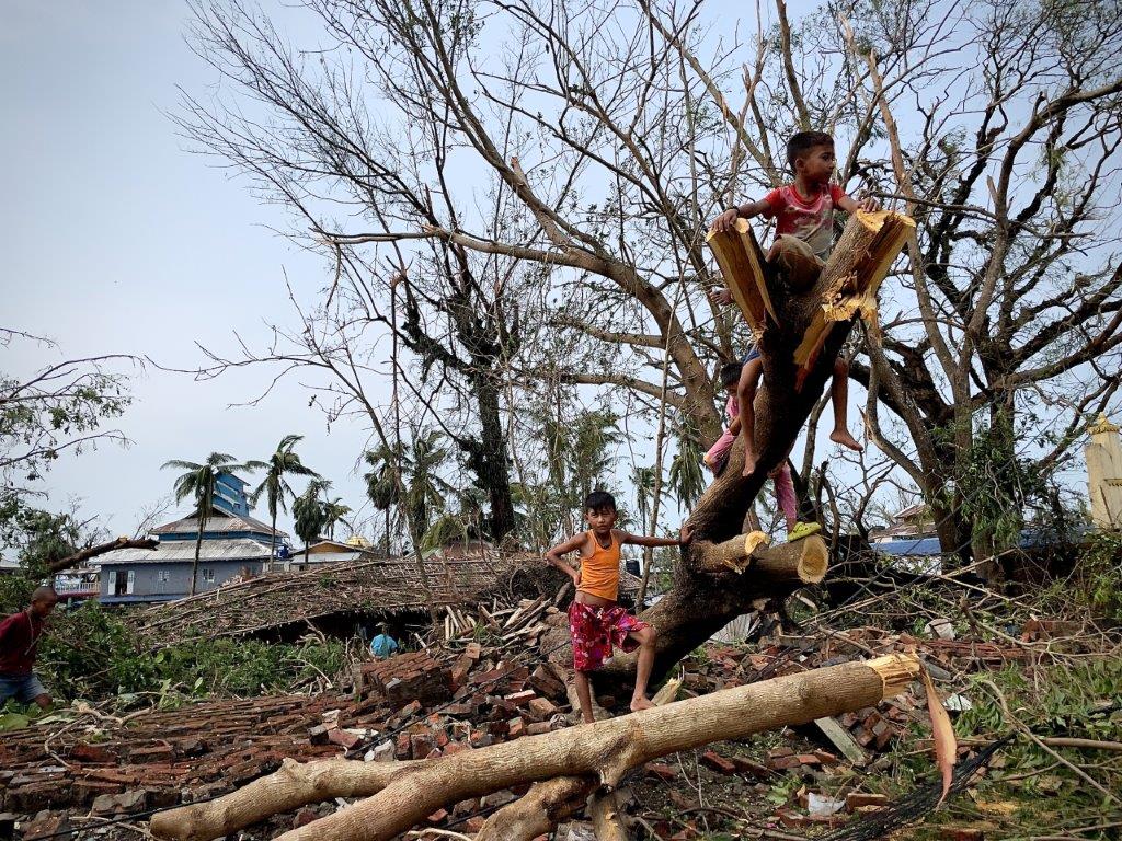 Unos niños juegan entre los árboles caídos tras el paso del ciclón Mocha en Sittwe, estado de Rakhine, Myanmar, el 14 de mayo de 2023. Crédito: UNICEF Myanmar /2023/Naing Lin Soe