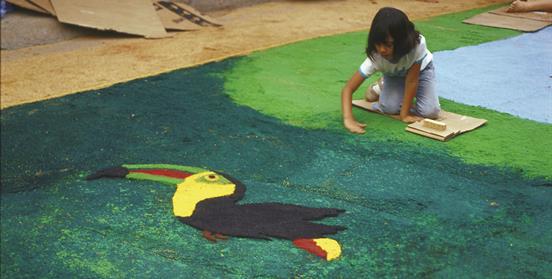 Niña pintando mural en el suelo