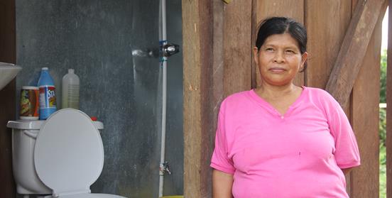 Mujer al lado de una letrina 