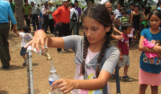 niña llena botella de agua en un grifo