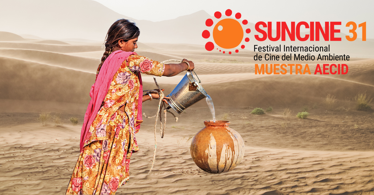 Una mujer llena una vasija de agua en una zona desértica. Aparece el texto: SUNCINE 31 Festival Internacional de Cine del Medio Ambiente Muestra AECID.