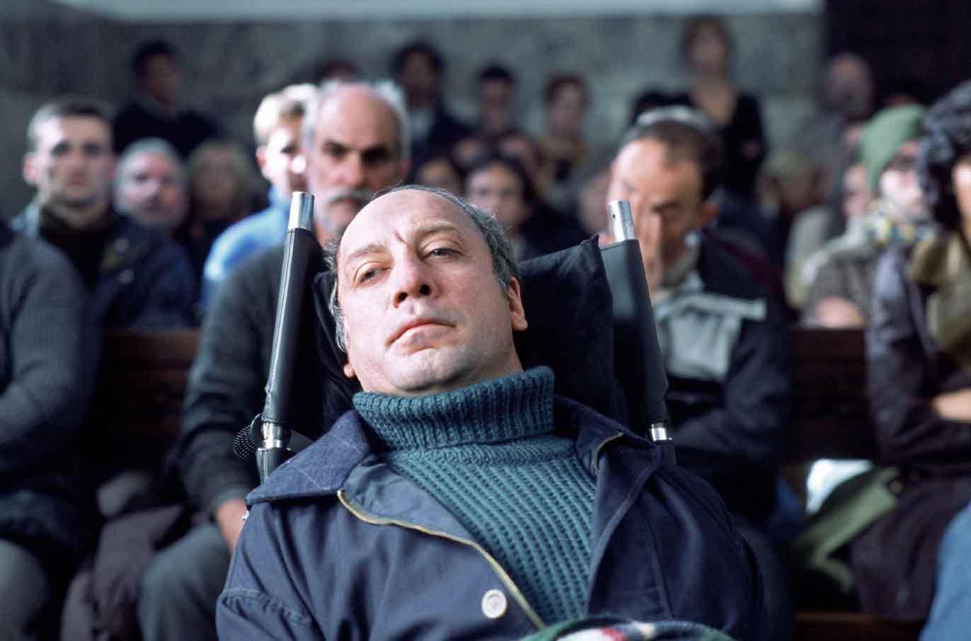 Fotografía de la sala de un juzgado en la que aparece un hombre de unos 50 años, postrado en una silla y mirando muy serio al frente. Detrás de él ...