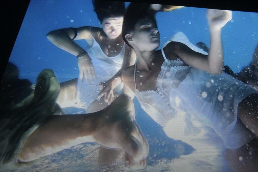 Mujeres vestidas de blanco sumergidas en el agua