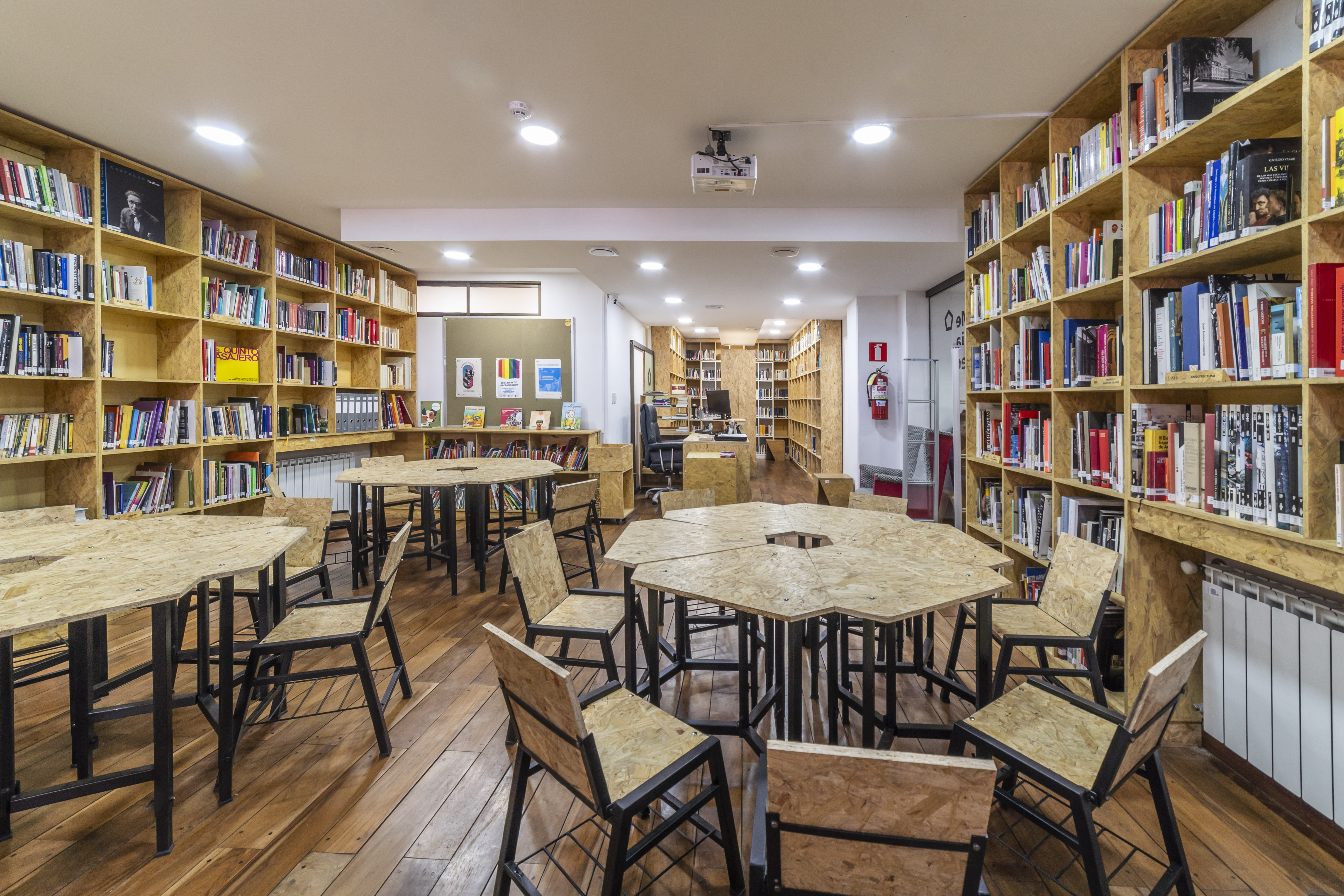 Sala con mesas y sillas y estanterías con libros