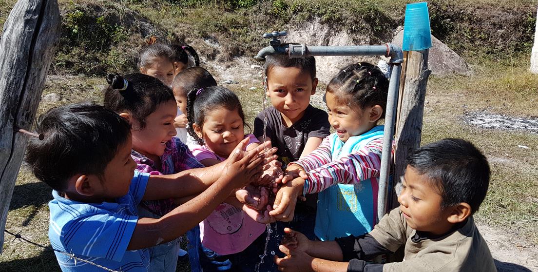 niños lavándose las manos con agua